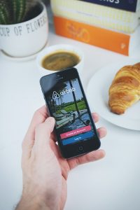 O que é o airbnb - foto de um celular com o aplicativo. É uma das formas de hospedagem compartilhada mas ensino como se hospedar de graça com o aibnb